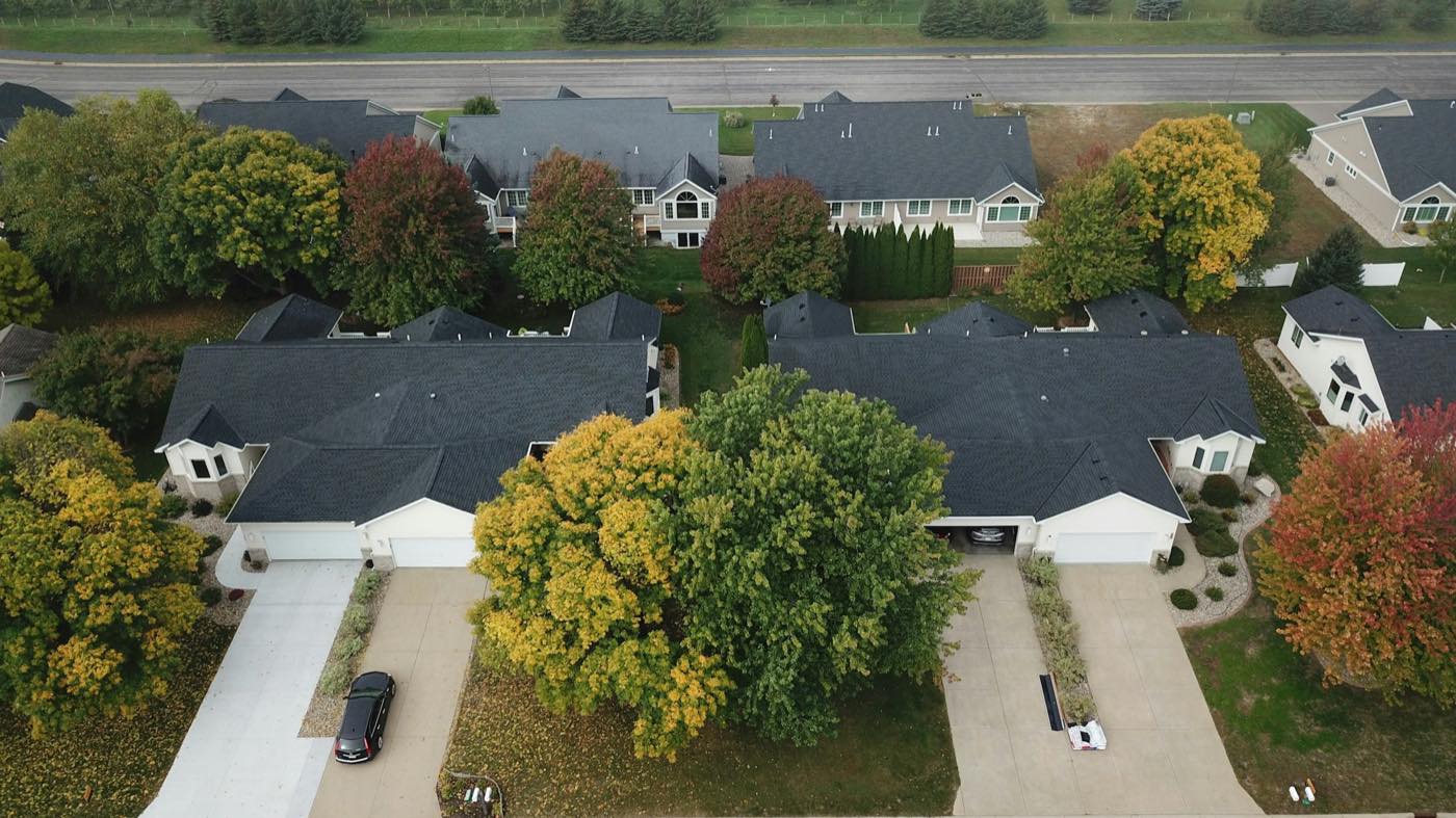 Aerial view of a neighborhood of shingle-roofed homes in autumn