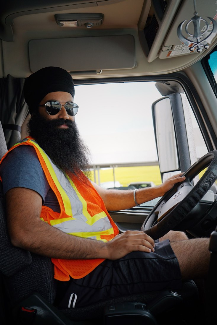 Truck driver in a safety vest at the wheel of his cab